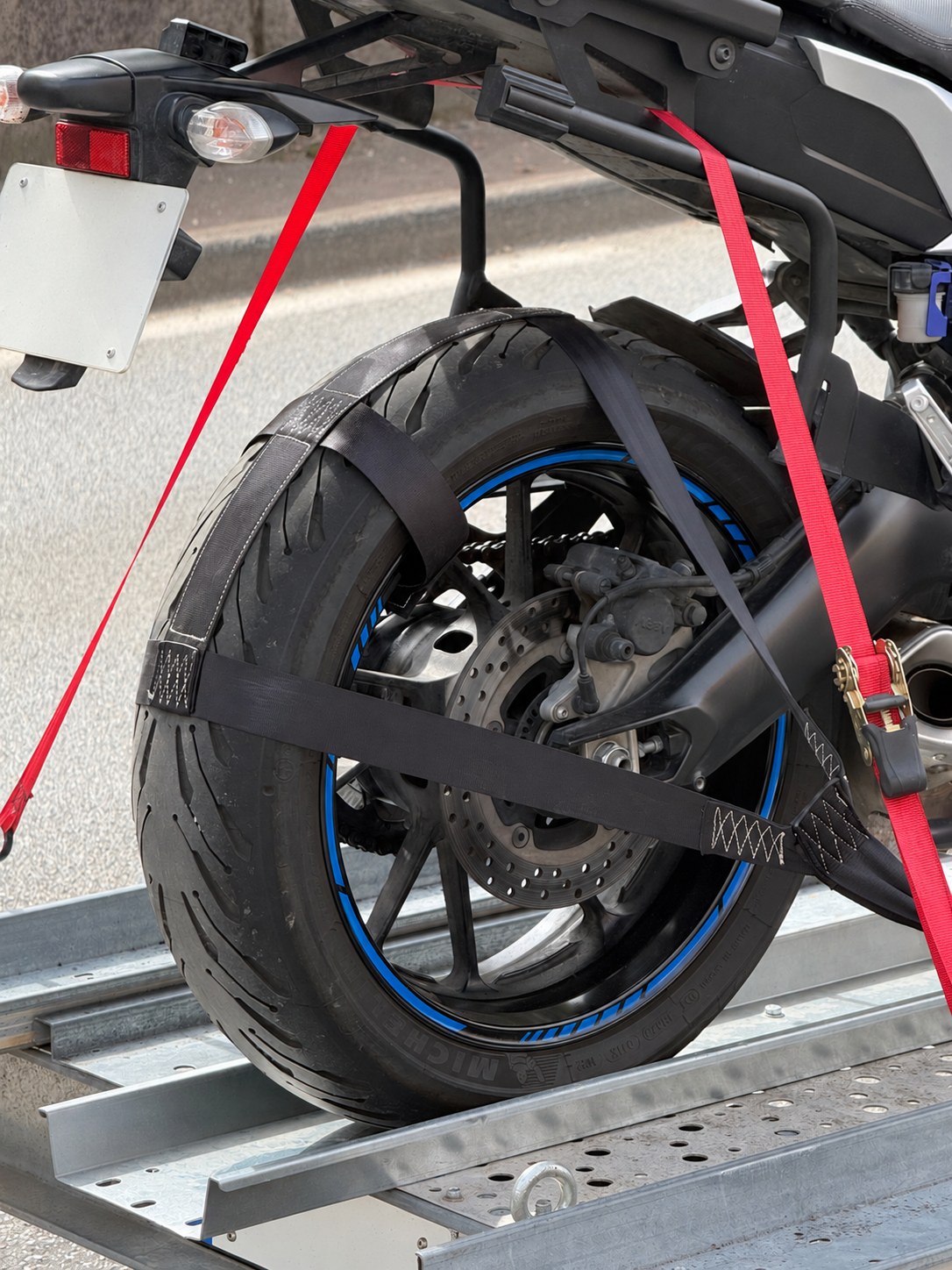 Motocicletta fissata sul rimorchio per il trasporto, con targhe oscurate
